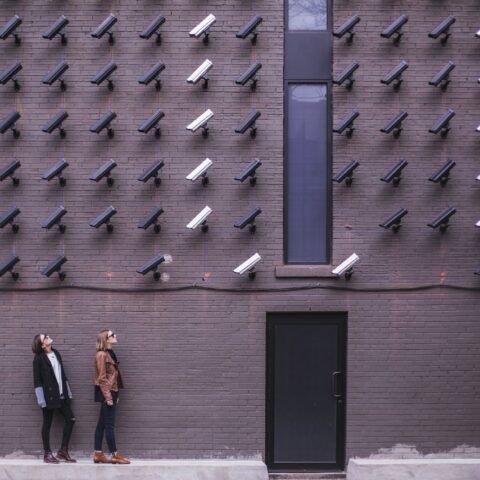 two person standing under lot of bullet cctv camera